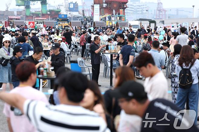 25일 오후 인천항 상상플랫폼에서 열린 제2회 1883 인천맥강파티에서 외국인 관광객들이 닭강정과 맥주를 즐기고 있다. 인천의 유명한 먹을거리인 닭강정과 함께 맥주를 즐길 수 있는 인천맥강파티는 외국인관광객을 유치하기 위해 마련됐다. 2024.5.25/뉴스1 ⓒ News1 신웅수 기자