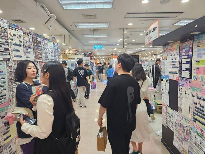 지난 18일 오후 3시쯤 서울 서초구의 국제전자센터 9층을 방문한 시민들이 통로를 걸어다니며 상점 벽에 전시된 쿠지(뽑기판)를 구경하고 있다./김병권 기자