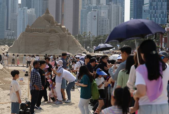 25일 오후 부산 해운대구 해운대해수욕장을 찾은 시민들이 모래 작품들을 감상하고 있다. 연합뉴스