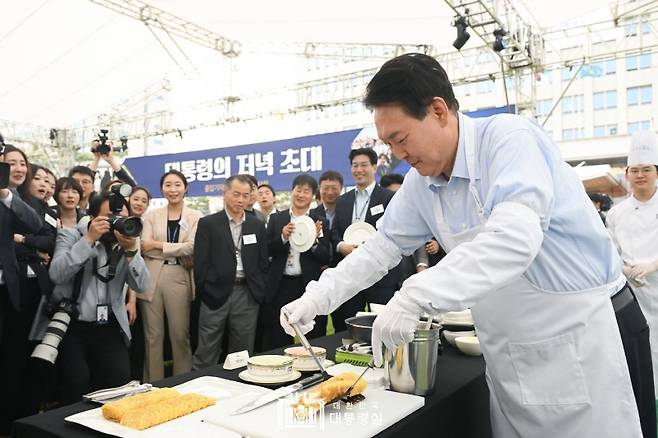 ▲윤석열 대통령이 24일 용산 대통령실 잔디마당에서 열린 '대통령의 저녁 초대' 만찬 행사에서 계란말이를 만드는 모습. ⓒ대통령실