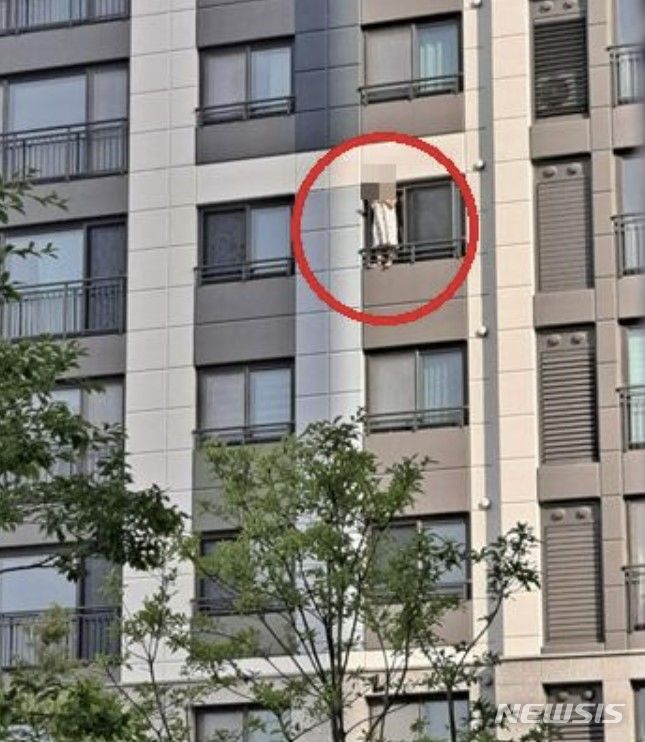 [서울=뉴시스]아파트 창틀에 서서 담배를 피우는 입주민 (사진=온라인 커뮤니티 캡쳐)