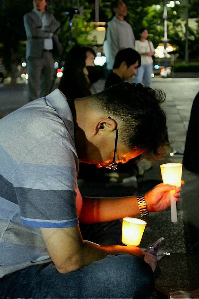 [부산=뉴시스] 24일 부산 동구 부산역 광장에서 '전세사기 특별법 촉구 개정 촉구 전국 동시다발 집회'가 개최됐다. 집회에 참가한 한 시민이 촛불을 들고 생각에 빠져 있다. (사진=영남권전세사기피해자연합대책위 제공) 2024.05.25. photo@newsis.com *재판매 및 DB 금지