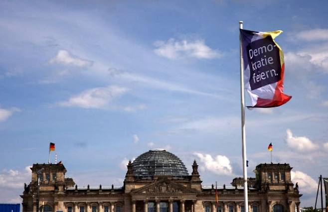 24일(현지시간) 독일 베를린 의회 의사당을 배경으로 ‘민주주의 축제’를 알리는 깃발이 펄럭이고 있다. 독일은 1949년 5월 23일 서독 기본법 발효 75주년을 맞아 이날부터 26일까지 사흘간 민주주의 축제 행사를 진행하는 중이다. 