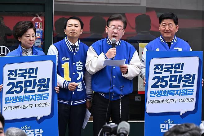 이재명 더불어민주당 대표가 총선을 앞둔 지난 3월 민주당 후보들과 함께 '총선 승리시 전국민 민생회복 지원금 25만원'을 지급하겠다고 공약하고 있다. /뉴스1