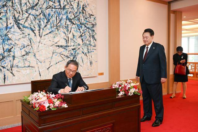 윤석열 대통령이 26일 서울 용산 대통령실 청사에서 리창(왼쪽) 중국 국무원 총리의 방명록 작성을 지켜보고 있다. 대통령실 제공