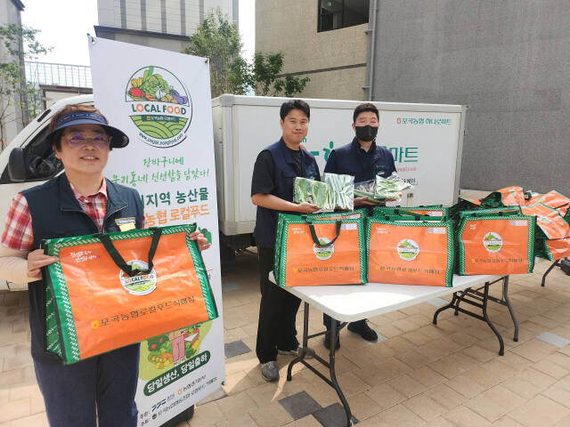 지난 24일 오후 3시께 용인시 처인구 서희스타힐스아파트에서 포곡 농협 하나로마트 직원들이 로컬푸드 꾸러미 무료 증정 이벤트를 진행했다. 이진기자