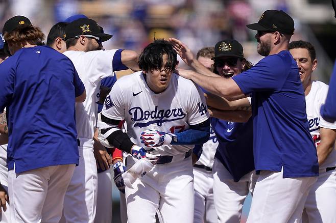 미국프로야구(MLB) 로스앤젤레스 다저스에서 활약하는 일본 야구스타 오타니 쇼헤이(가운데)가 19일(현지시간) 캘리포니아주 로스앤젤레스 다저스타디움에서 열린 신시내티 레즈와 홈 경기에서 연장 10회 끝내기 안타를 치고 동료들의 축하를 받고 있다. 이날 LA다저스는 오타니의 끝내기 안타로 3-2로 승리하며 3연승을 질주했다. [연합]