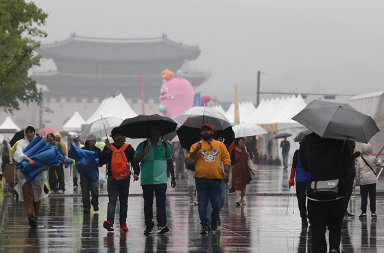 26일 오후 비가 내리는 서울 광화문광장에서 시민들이 우산을 쓴 채 걸어가고 있는 모습. 〈자료사진=연합뉴스〉