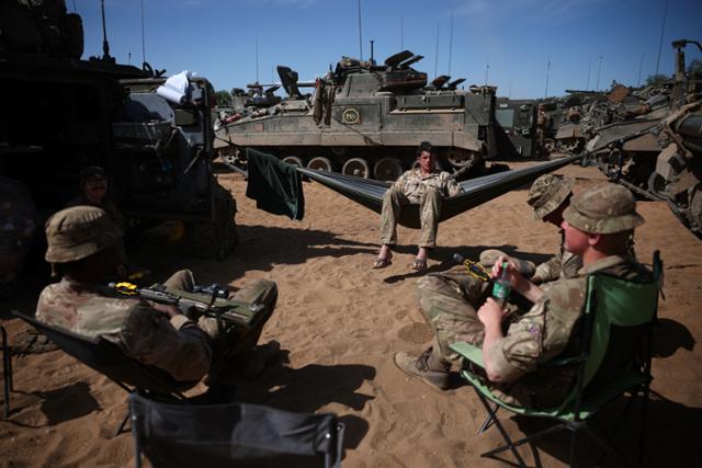 영국 육군 소속 군인들이 지난 15일 폴란드 드라프스코포모르스키에 지역에서 북대서양조약기구(NATO·나토) 연합 훈련을 하던 중 휴식을 취하고 있다. 로이터 연합뉴스