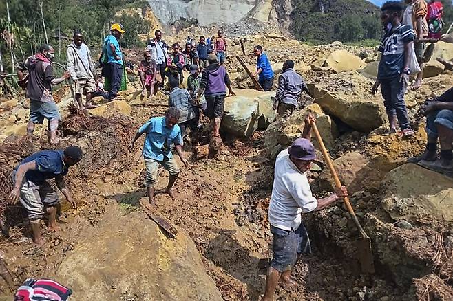 산사태가 덮친 파푸아뉴기니 포제라 마을에서 26일(현지시간) 주민들이 직접 도구를 들고 실종자를 찾고 있다. AP연합뉴스