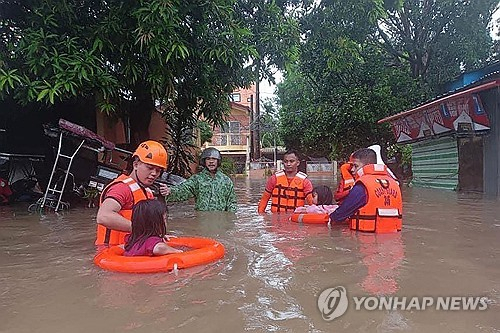 (마닐라 AFP=연합뉴스) 지난 26일(현지시간) 필리핀 북부 루손섬 케손주 루세나에서 태풍 에위니아로 거리가 물에 잠긴 가운데 주민들이 대피하고 있다. 2024.5.27