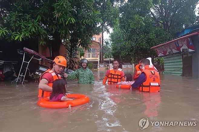 필리핀, 올해 1호 태풍 에위니아에 침수 피해 (마닐라 AFP=연합뉴스) 지난 26일(현지시간) 필리핀 북부 루손섬 케손주 루세나에서 태풍 에위니아로 거리가 물에 잠긴 가운데 주민들이 대피하고 있다. 2024.5.27