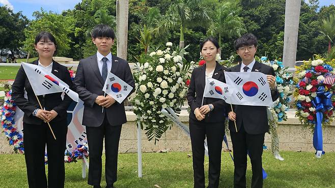 국제청소년연합 산하 굿뉴스코 해외봉사단 단원들이 27일 미국령 푸에르토리코 바야몬시의 국립묘지에서 태극기를 들고 기념촬영을 하고 있다. /IYF푸에르토리코 제공