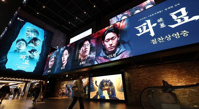 지난 3월 10일 서울의 한 영화관에 ‘파묘’ 홍보물 앞으로 시민들이 지나가고 있다. /뉴스1