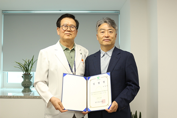 이영성(오른쪽) 충북대학교 의과대학 교수가 28일 김영규 청주의료원장으로부터 충북도 공공보건의료지원단장 임명장을 받고 있다. [사진=청주의료원]