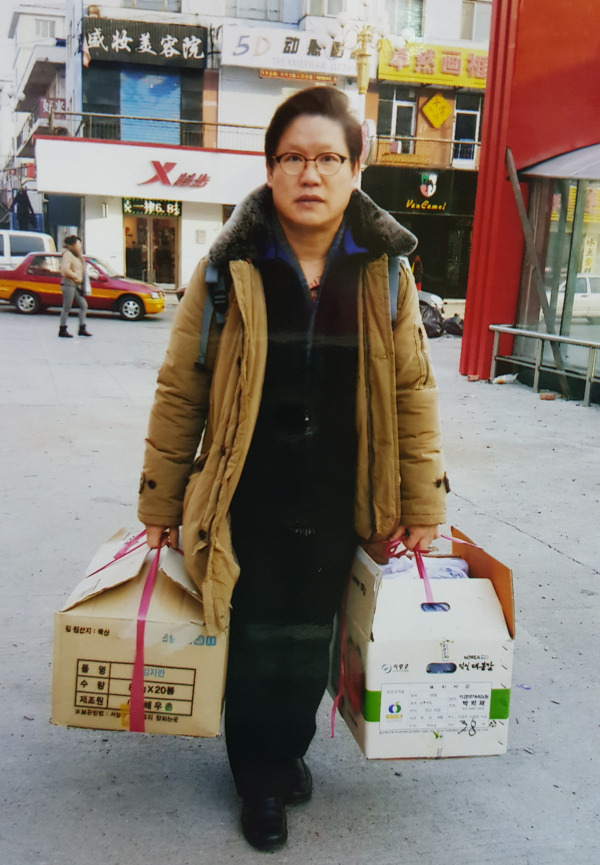 국경지대의 탈북자들을 돕기 위하여 구호물자를 등에 메고 또 양손 가득히 들고 가는 박용배 목사.
