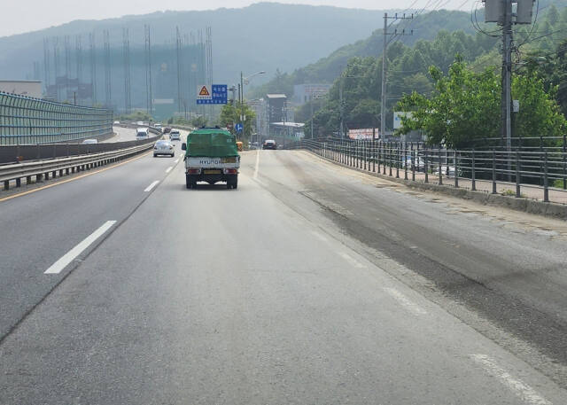 용인특례시 수지구의 한 도로 차선이 도색이 벗겨진 채 흙과 모래 등으로 덮여져 운전자가 식별하기 어려운 상태로 방치돼 있다. 한준호기자