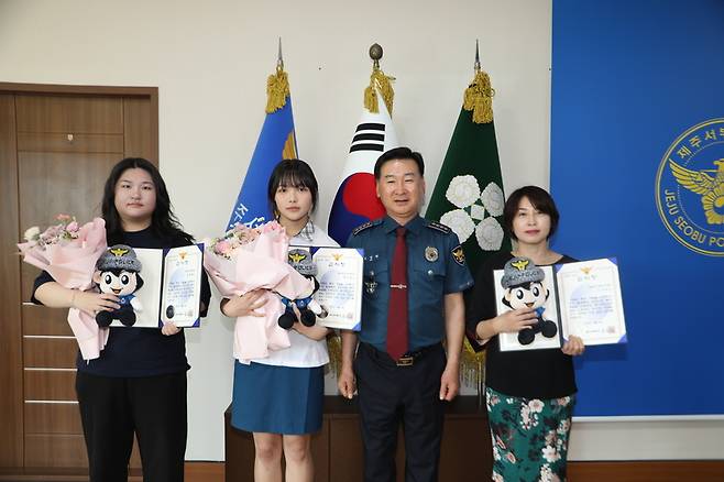 제주중앙여자고등학교 1학년 정영채·조서원 학생(왼쪽)과 농협은행 제주도청지점 강경희 부지점장(가장 오른쪽)  / 제주서부경찰서 제공