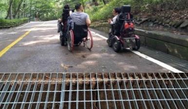 A drainage cover on the approach to the barrier-free forest path in Gwanaksan Mountain, Seoul, which is difficult for wheelchair users to pass.