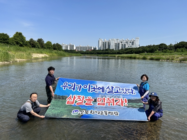 전북환경운동연합 관계자들이 29일 전주 삼천 마전교 주변 물속에서 기자회견을 열고 과도한 하천 준설 작업을 멈추라고 주장하고 있다. 전북환경운동연합 제공.