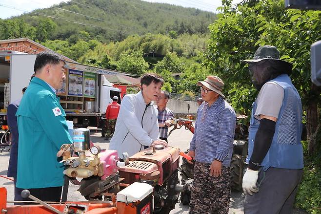 [밀양=뉴시스] 안병구 경남 밀양시장이 28일 상동면 매화마을에서 열린 농기계 순회수리 교육 현장에서 고장 난 농기계를 살펴보고 농민들의 고충 사항을 듣고 있다. (사진=밀양시 제공) 2024.05.29. photo@newsis.com   *재판매 및 DB 금지