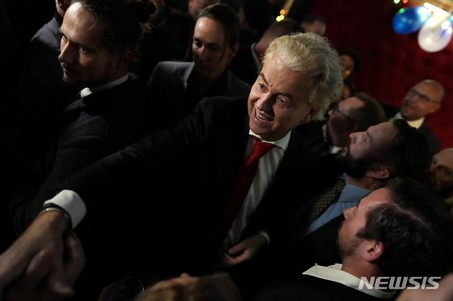 [헤이그=AP/뉴시스]헤이르트 빌더르스(가운데) 네덜란드 자유당(PVV) 대표가 22일(현지시각) 네덜란드 헤이그에서 총선 뒤 발표된 출구조사 결과에 웃고 있다. 2023.11.23.