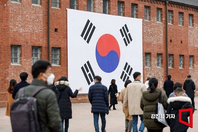 서대문형무소역사관을 찾은 시민들이 역사관 외벽에 걸린 대형태극기를 바라보고 있다. 사진=강진형 기자aymsdream@