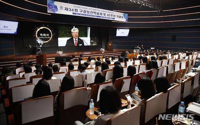 [창원=뉴시스]29일 마산대학교 청강홀에서 열린 치위생과 주최 ‘제34회 구강보건학술제 및 학과 개설 40주년 기념’에 참석한 학생들이 이학진 총장의 영상 축사를 듣고 있다.(사진=마산대 제공) 2024.05.30. photo@newsis.com