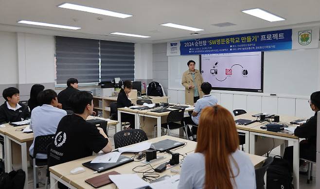 지난 30일 아산중학교에서 개최한 ‘SW 명문 중학교 만들기’ 발대식에서 AI·빅데이터학과 문지훈 교수가 재학생 멘토와 중학생 멘티들을 대상으로 연구주제에 관해 소개하고 있다. (사진 제공=순천향대)