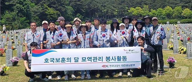 한국도로공사 대전충남본부가 국립대전현충원에서 묘역 정비 활동을 펼치고 기념사진으 촬영하고 있다. (도로공사 대전충남본부 제공) /뉴스1