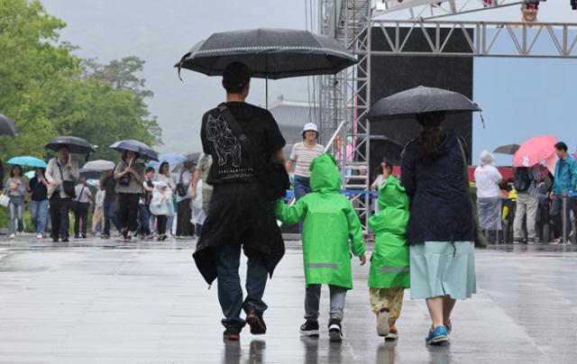 지난달 26일 비가 내리는 서울 광화문광장에서 우산을 나눠 쓴 가족이 걸어가고 있다. 뉴시스