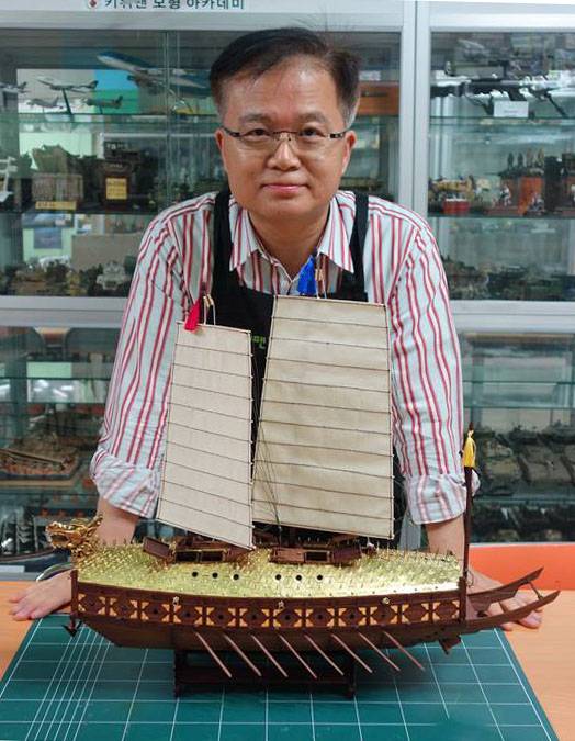 직접 제작한 거북선과 포즈를 취한 강신금 작가