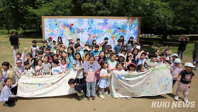 그린피스가 1일 서울 송파구 올림픽공원에서 개최한 ‘퍼즐모아 바다호보’ 행사에 참가한 어린이들이 어린이들이 직접 만든 초대형 퍼즐 앞에서 바다를 지켜달라고 외치고 있다.