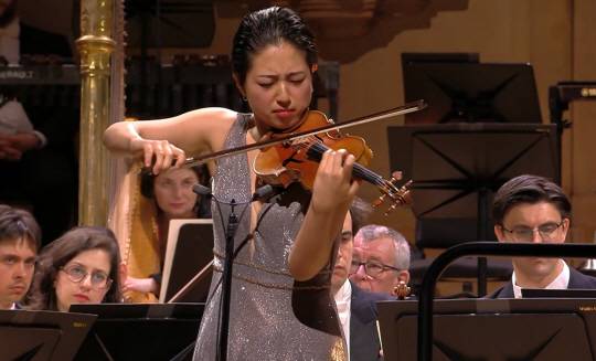 바이올리니스트 최송하가 퀸 엘리자베스 콩쿠르 결선 무대에서 쇼스타코비치 바이올린 협주곡을 연주하고 있다. 객석의 기립박수를 이끌어 냈지만, 아쉽게도 입상은 하지 못했다. 퀸엘리자베스 콩쿠르 홈페이지 캡처