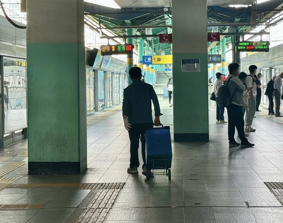 지하철 이동상인 김모(76)씨가 지난 5월 27일 파란 통이 달린 카트를 끌고 이동하고 있다. 김홍준 기자