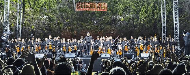 지난 2일 강원 계촌로망스파크에서 열린 계촌클래식축제 ‘별빛콘서트’에서 지휘자 김선욱이 이끄는 경기필하모닉 오케스트라가 연주를 마친 뒤 인사하고 있다.  현대차 정몽구재단 제공