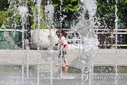 서울 한낮 기온이 28도까지 오르며 더운 날씨를 보인 3일 오후 한 어린이가 서울 종로구 광화문광장 분수대에서 놀고 있다. {연합뉴스]