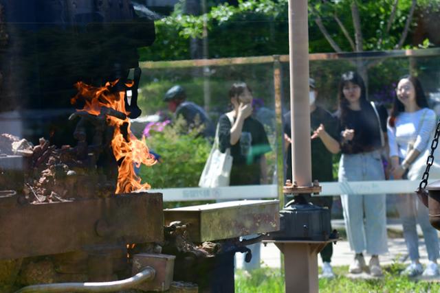 윤석열 대통령이 경북 포항시 영일만 앞바다에 140억 배럴 석유와 가스가 매장돼 있다고 발표한 3일 오후 포항 남구 대잠동 철길 숲&불의 정원에서 시민들이 뿜어져 나오는 불길을 지켜보고 있다. 뉴스1