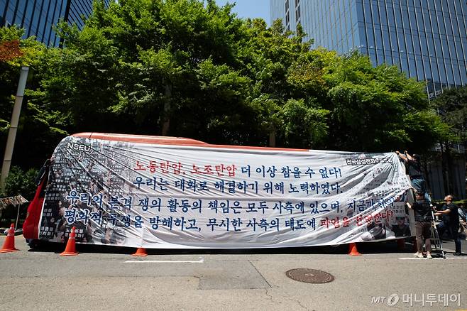 (전국삼성전자노동조합 조합원들이 29일 서울 강남구 삼성전자 서초사옥 앞에서 파업 선언 기자회견을 마친 후 대형버스에 현수막을 매다는 퍼포먼스를 하고 있다.  삼성전자 최대 노조인 전국삼성전자노조는 삼성전자 창사 이후 첫 파업을 선언하며 "사측이 교섭 조건을 받아들이지 않아 즉각 파업에 임한다"며 "모든 책임은 노조를 무시하는 사측에 있다"고 주장했다. /사진제공=뉴스1