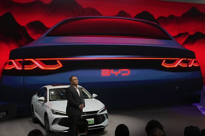지난달 베이징에서 열린 오토차이나 2024에서 BYD 관계자가 새 모델과 콘셉트카를 공개하고 있다.