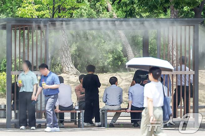 서울 지역의 낮 최고기온이 31도까지 올라 더위가 찾아온 5일 서울 영등포구 여의도공원에서 시민들이 쿨링포그 아래 무더위를 쫓고 있다. 2024.6.5/뉴스1 ⓒ News1 민경석 기자