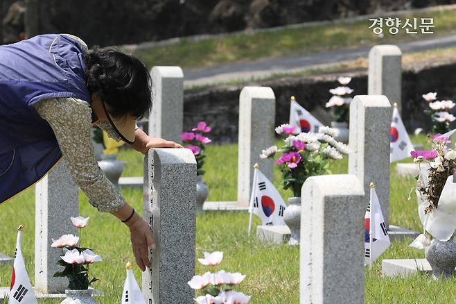 5일 서울 동작구 국립서울현충원에서 참배객이 묘비를 쓰다듬고 있다.