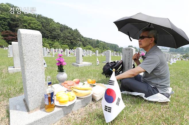 5일 서울 동작구 국립서울현충원을 찾은 참배객이 동료의 묘비 앞에 앉아있다.