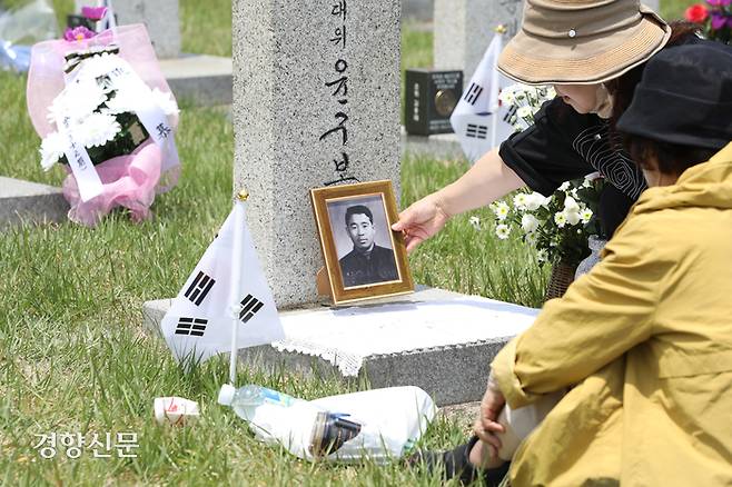 5일 서울 동작구 국립서울현충원을 찾은 참배객이 묘비에 사진을 놓고있다.