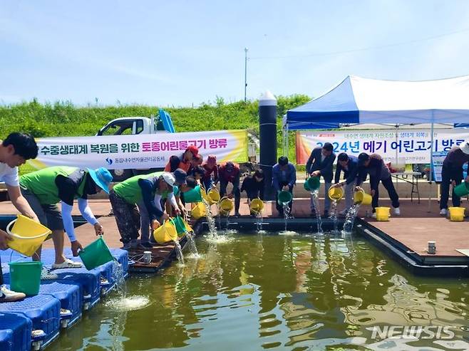 [창원=뉴시스]5일 경남 창원시 의창구 주남저수지에서 경상남도수산자원연구소 민물고기연구센터, 창원시청 관계 공무원, 동읍 내수면 어업계원, 마을주민 등이 어린 메기 3만5000마리를 방류하고 있다.(사진=경남도 민물고기연구센터 제공) 2024.06.05. photo@newsis.com