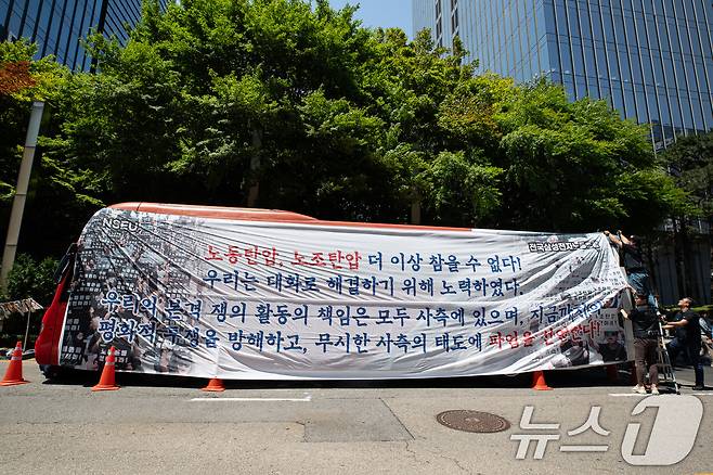 전국삼성전자노동조합 조합원들이 29일 서울 강남구 삼성전자 서초사옥 앞에서 파업 선언 기자회견을 마친 후 대형버스에 현수막을 매다는 퍼포먼스를 하고 있다. 2024.5.29/뉴스1 ⓒ News1 유승관 기자