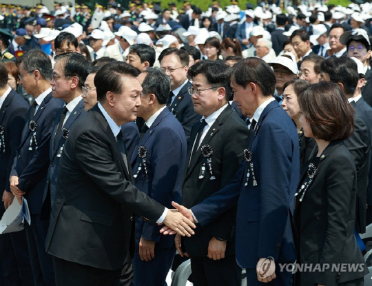 윤석열 대통령이 6일 서울 동작구 국립서울현충원에서 열린 제69회 현충일 추념식이 끝난 뒤 퇴장하며 조국 조국혁신당 대표와 악수하고 있다. <연합뉴스>