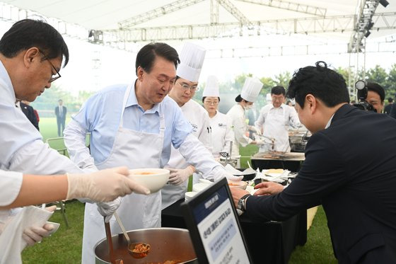 윤석열 대통령이 5월24일 용산 대통령실 잔디마당에서 김치찌개를 만들어 출입기자들에게 배식하고 있다. 이 음식에 대한 윤 대통령의 애정은 검찰 재직 시절부터 유명했다. 사진 대통령실.