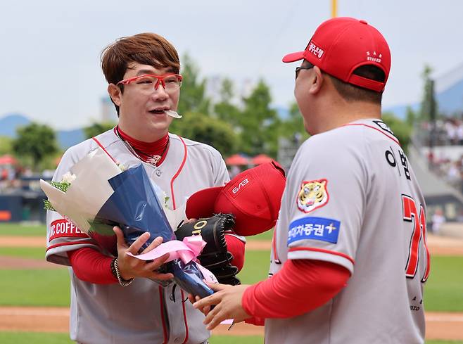 이범호 KIA 감독(오른쪽)이 6일 광주 기아챔피언스필드에서 열린 2024 프로야구 롯데와 경기에서 2000탈삼진 기록을 세운 양현종에게 축하 꽃다발을 전하고 있다.  광주 | 연합뉴스