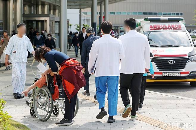 (서울=뉴스1) 민경석 기자 = 정부의 의대 정원 확대에 반발하는 전공의를 비롯한 의료계의 집단행동이 장기화 되고 있는 9일 서울의 한 대학병원에서 환자와 의료진이 오가고 있다.   의료계에 따르면 19개 대학이 참여하는 전국 의대교수 비상대책위원회(전의비)는 10일 전국적인 휴진에 들어갈 예정이다. 2024.5.9/뉴스1  Copyright (C) 뉴스1. All rights reserved. 무단 전재 및 재배포,  AI학습 이용 금지. /사진=(서울=뉴스1) 민경석 기자